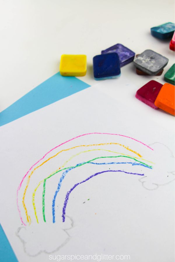 a close-up of a rainbow drawing made with crayons, with DIY block crayons scattered in the background