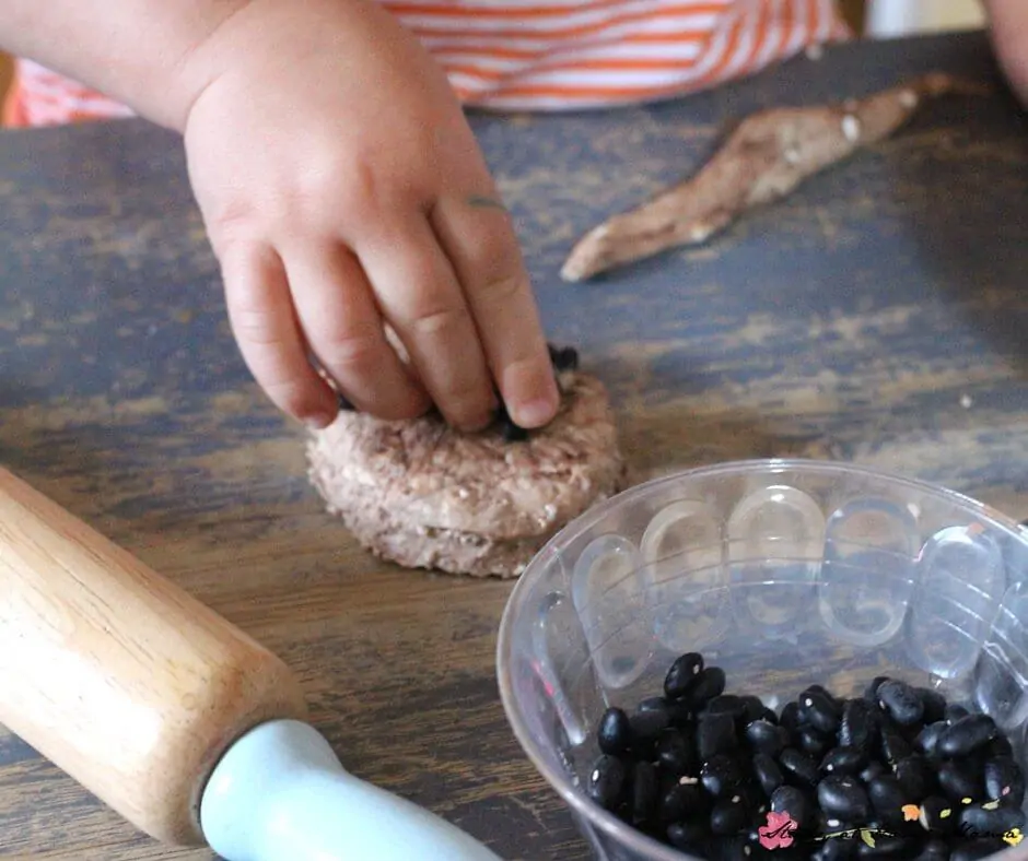 Putting black bean "chocolate chips" onto our play dough cookies