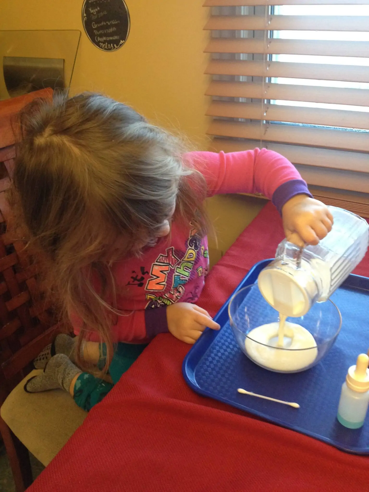 milk and dish soap experiment: pouring milk is a montessori practical life skill used in this fun science experiment