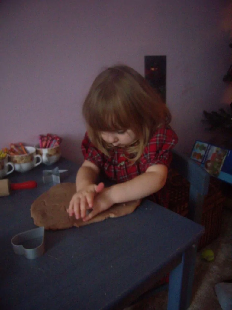 Ella making gingerbread play dough ornaments
