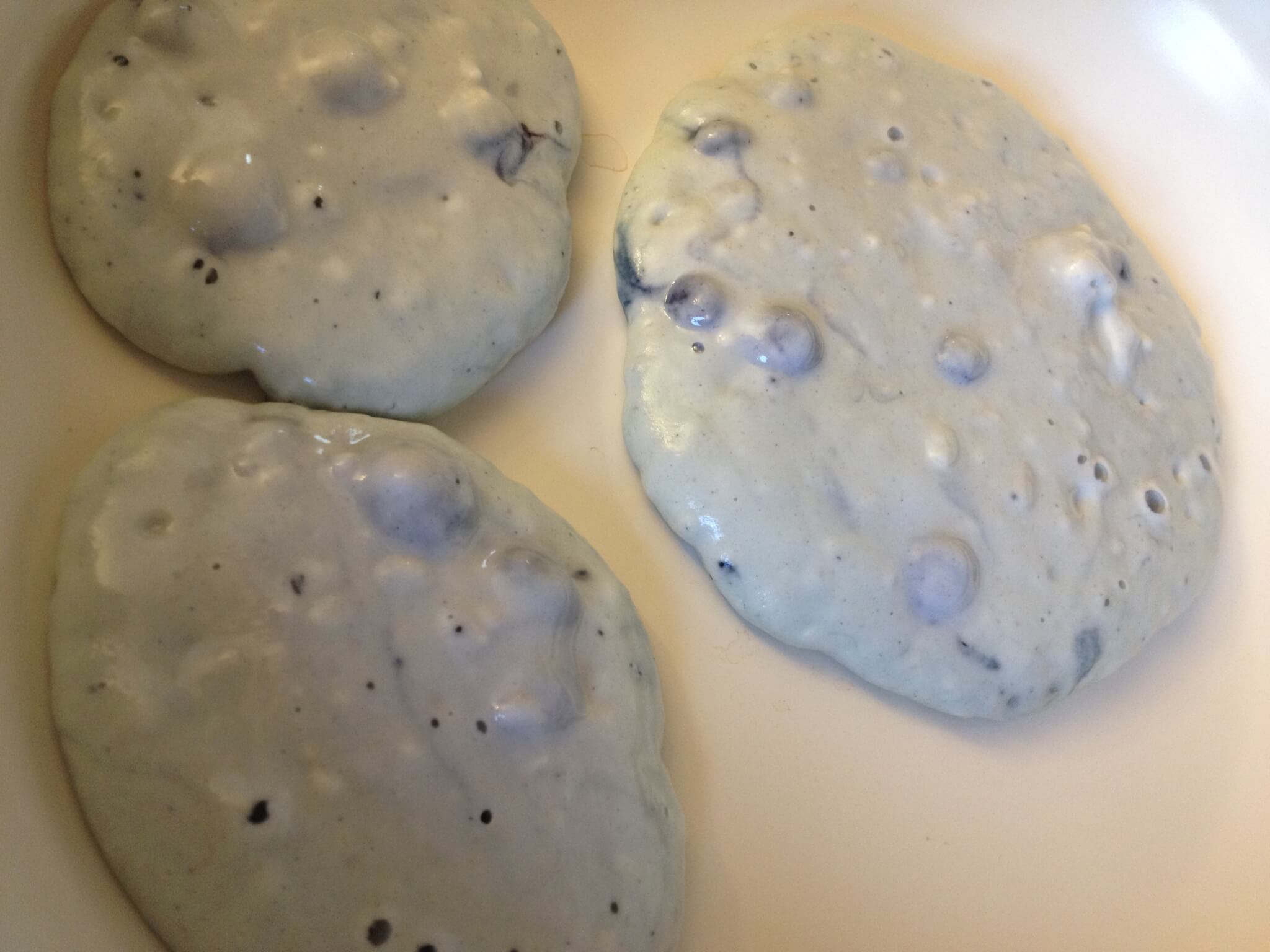 Cooking Frozen-inspired protein blueberry pancakes on a ceramaic frying pan requires no butter or oil.