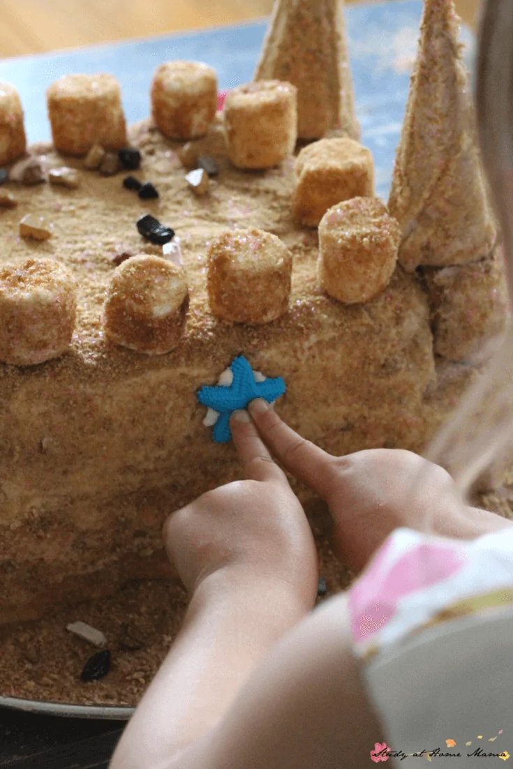 Chocolate rocks and icing starfish make the perfect toppings for this homemade sandcastle cake - perfect for a beach themed party