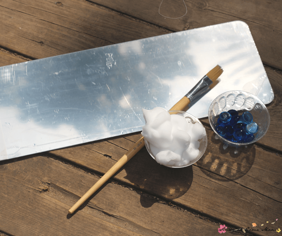 Materials Needed for Cloud Painting Sensory Activities for Children: Unbreakable mirror, shaving cream, and glass gems