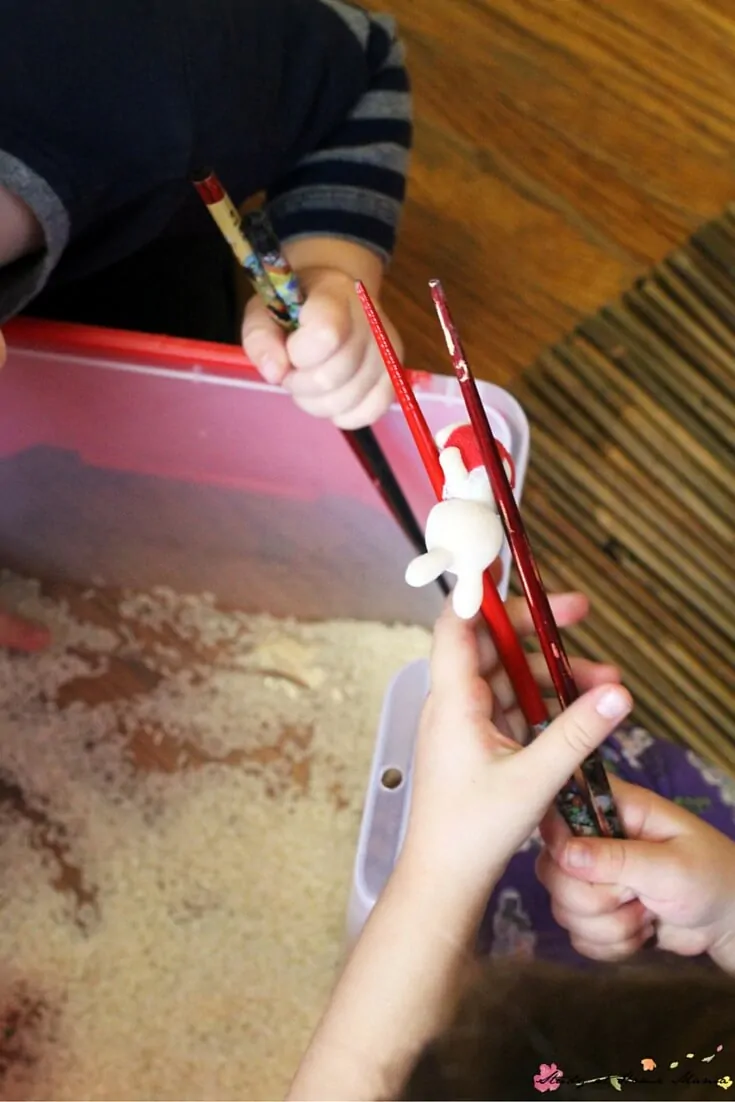 Learning how to pick up items with chopsticks, using a fun sensory bin invitation