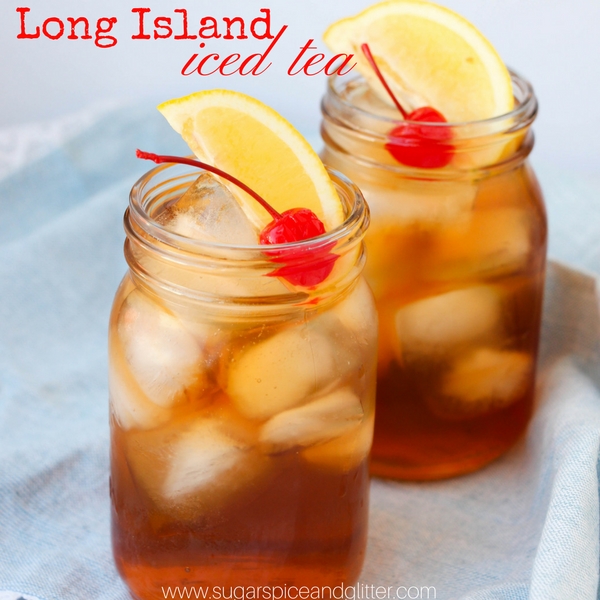 image of two mason jars full of Long Island Iced Tea garnished with lemon wedges and maraschino cherries on a denim napkin