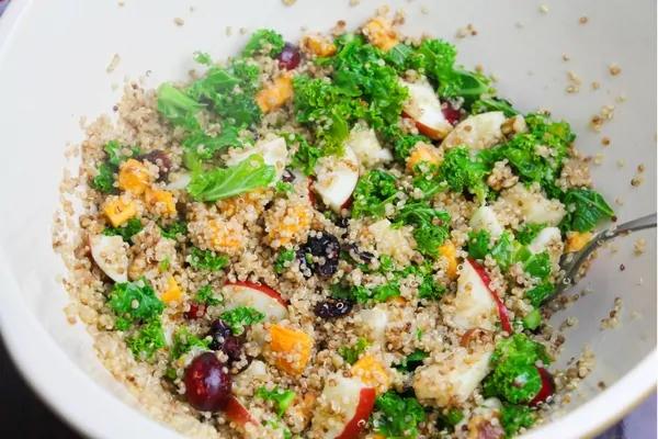 A flavorful quinoa salad with kale, apples, cranberries, sweet potatoes and walnuts