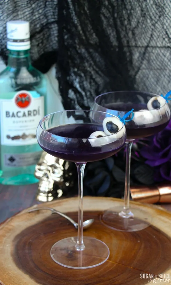 A spooky Halloween rum cocktail with edible fruit eyeballs skewered for a ghoulish touch