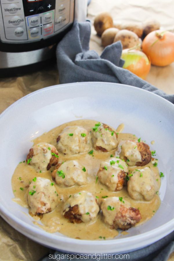 swedish meatballs and gravy in a blue bowl sprinkled with parsley