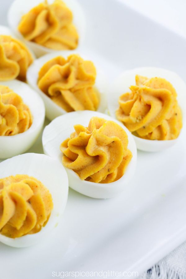 close up photo of deviled eggs on a white platter