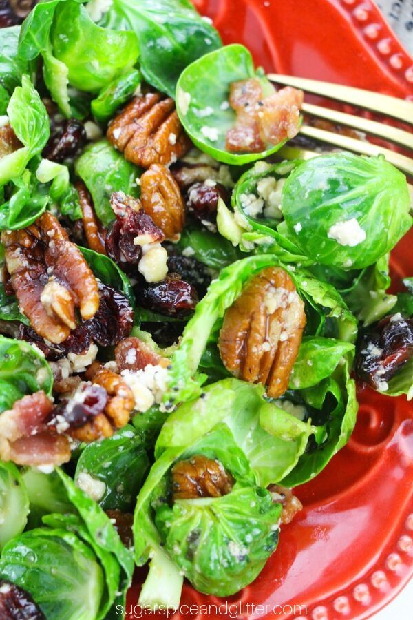The best fall salad! This brussel sprout salad with feta cheese, pecans, dried cranberries and fresh bacon bits is topped with pomegranate poppyseed dressing for the most delicious salad you will make this fall!