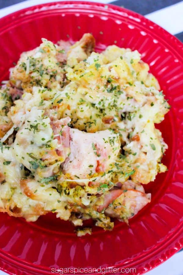 creamy chicken cordon bleu casserole on a red plate and garnished with parsley