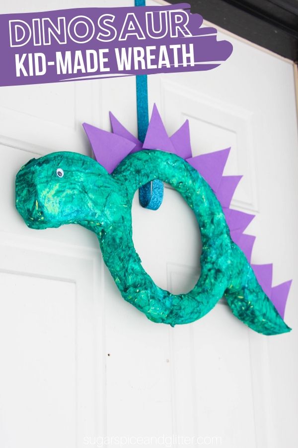 How to make a Super Simple Dinosaur Wreath, a fun dinosaur craft preschoolers can make! It would be great for a dinosaur party, after reading Puff the Magic Dragon, or for a Good Dinosaur movie night