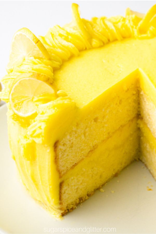 A lemon layer cake with bright yellow frosting and a slice cut out