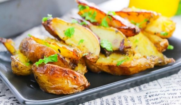 Greek roasted potatoes on a black plate