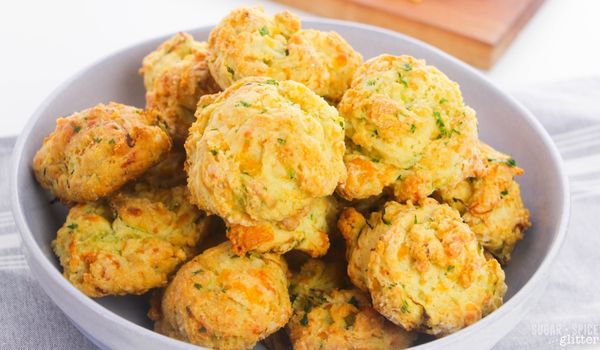 blue bowl filled with cheddar zucchini biscuits on a gray napkin