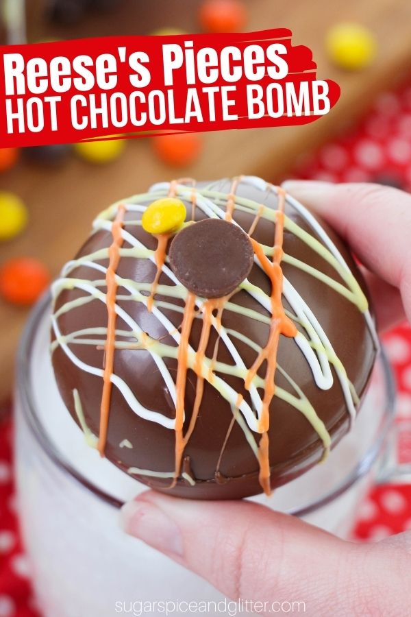 A decadent hot chocolate bomb filled with hot cocoa mix and peanut butter powder to make the ultimate peanut butter hot chocolate - a must-try for Reese's Pieces fans!