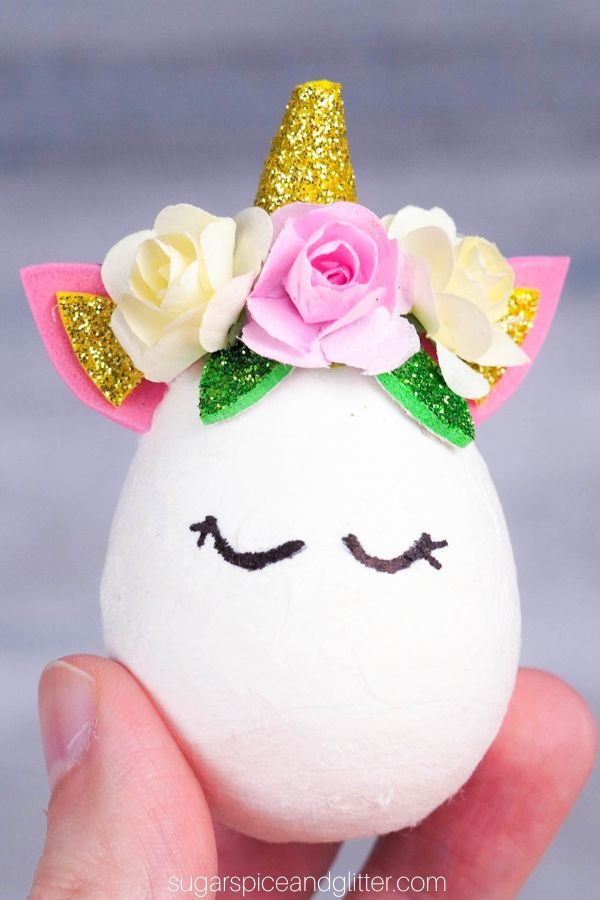 close-up shot of an Easter Egg decorated with a unicorn horn, ears and a flower crown