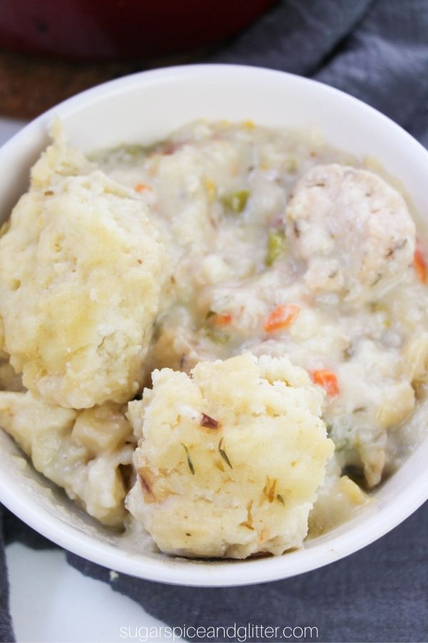 close-up image of a white bowl filled with chicken and dumpling stew on a gray napkin