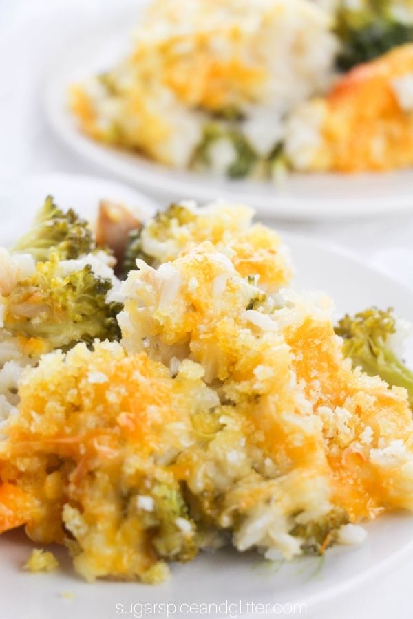 two small white plates filled with broccoli chicken casserole topped with cheese and bread crumbs