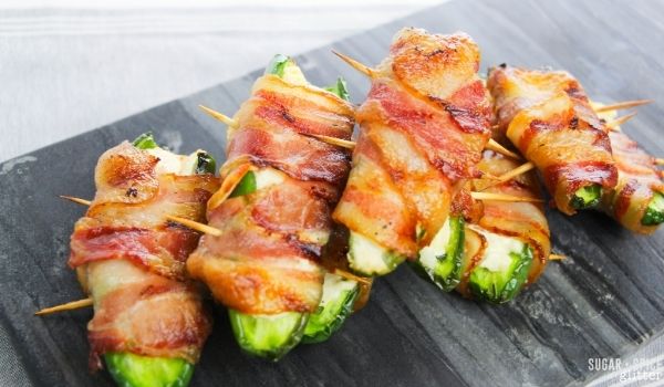 bacon-wrapped jalapeno poppers on a slate gray tray