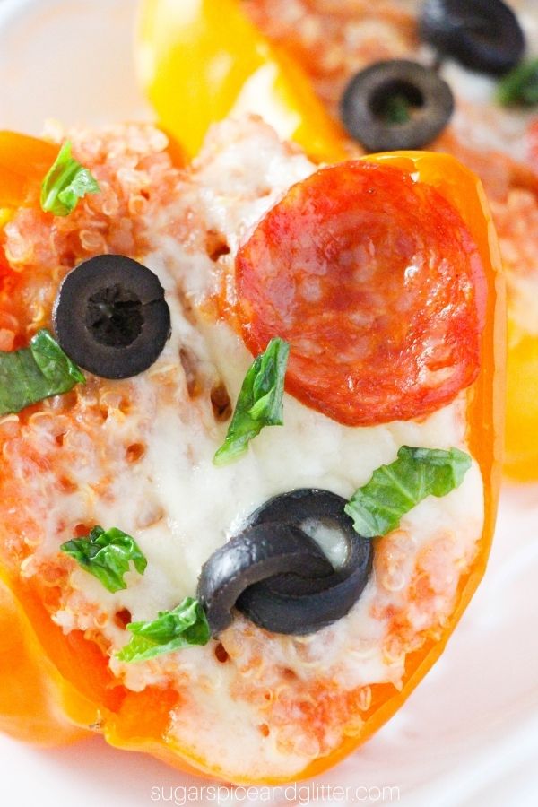 close-up of a bell pepper stuffed with quinoa and topped with melted cheese, black olives and pepperoni