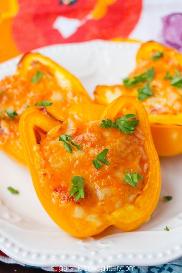 close-up shot of a taco-stuffed yellow bell pepper on a white plate, sprinkled with cilantro