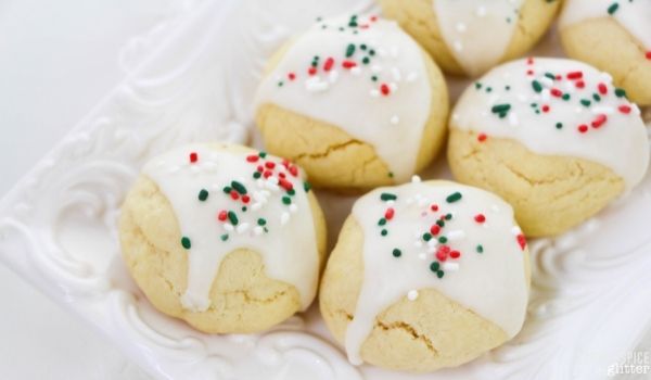 Italian sugar cookies on a white platter set on a light white napkin