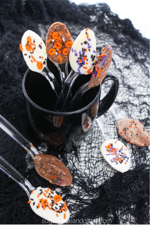 a black mug full of Halloween chocolate spoons on a black web fabric