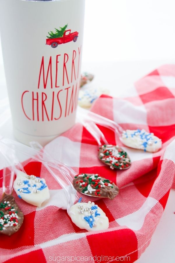 an assortment of Christmas chocolate spoons with a Christmas mug of coffee in the background