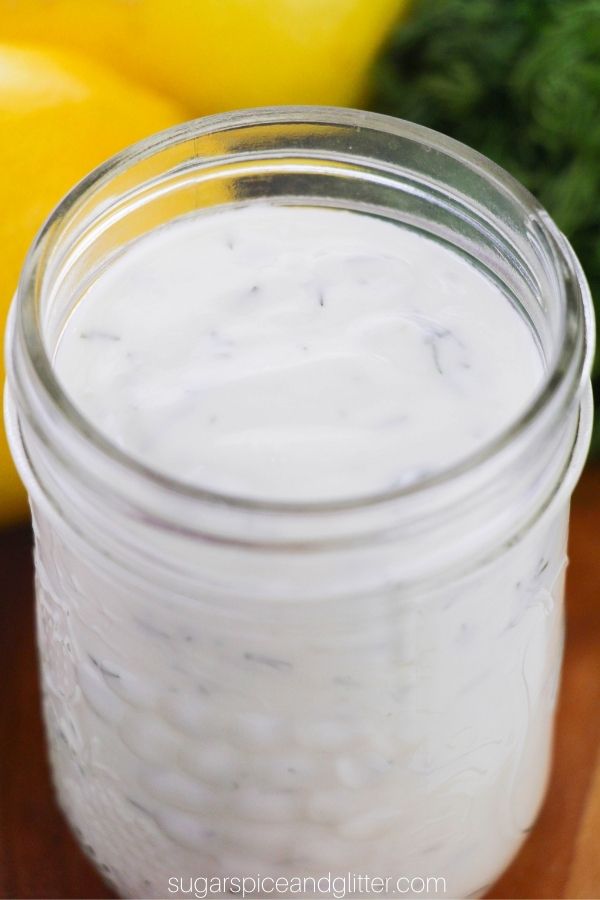 close-up picture of a mason jar of creamy lemon dill salad dressing