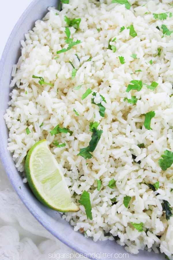 close-up of a light blue bowl filled with cilantro lime rice, garnished with lime wedges