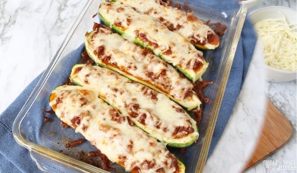 a glass casserole dish filled with baked taco-stuffed zucchini boats