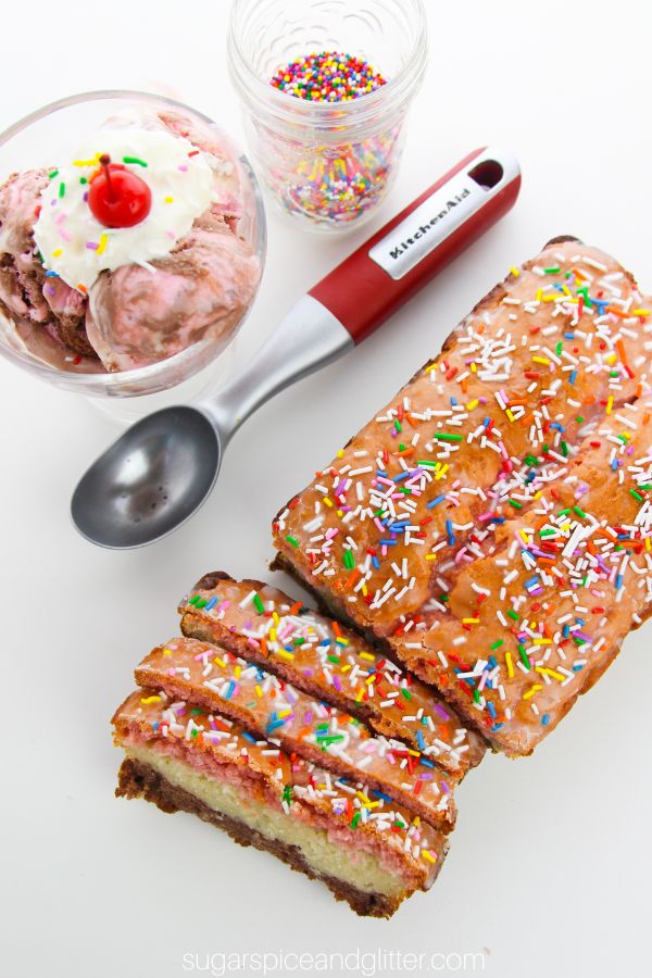 overhead image of a Neapolitan ice cream bread on a white table garnished with sprinkles, set beside a glass ice cream dish full of Neapolitan ice cream