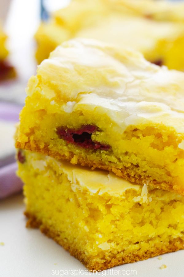 close-up image of a stack of lemon raspberry blondies in front of a purple napkin