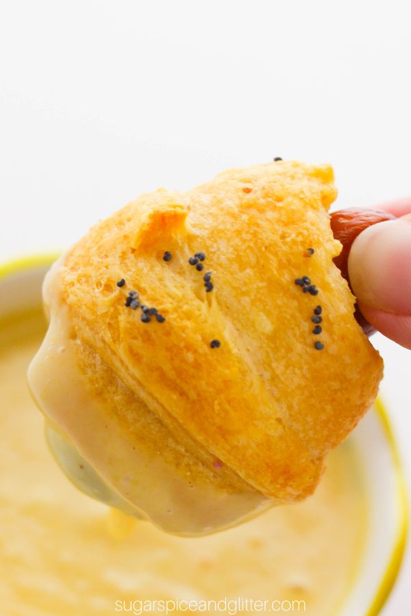 close-up image of a piggies in a blanket dipped in dijon mayo dipping sauce