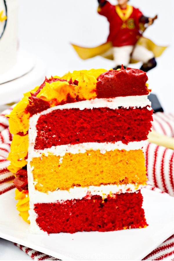 close-up image of a slice of Harry Potter cake with layers of maroon and gold cake with a Harry Potter figurine in the background