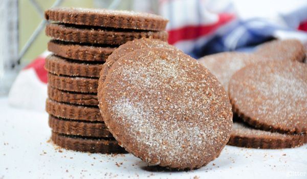 stack of Mexican chocolate cookies on a white countertop with a blue plaid napkin in the background