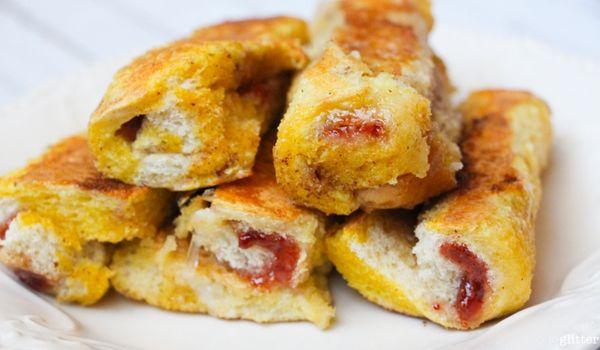 a stack of pb&j french toast roll ups on a white plate
