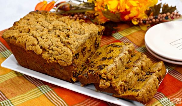 pumpkin coffee cake on a white platter set on an orange plaid tablecloth