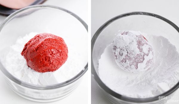 rolling a ball of red velvet cookie dough in powdered sugar.