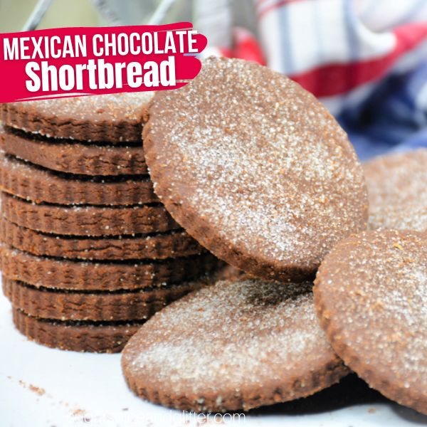 pile of Mexican chocolate cookies on a white countertop with a blue plaid napkin in the background