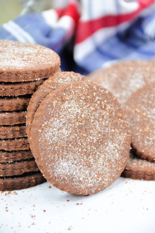 close-up image of Mexican chocolate cookies on a white countertop with a blue plaid napkin in the background