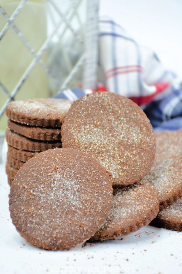 pile of Mexican chocolate cookies on a white countertop with a blue plaid napkin in the background