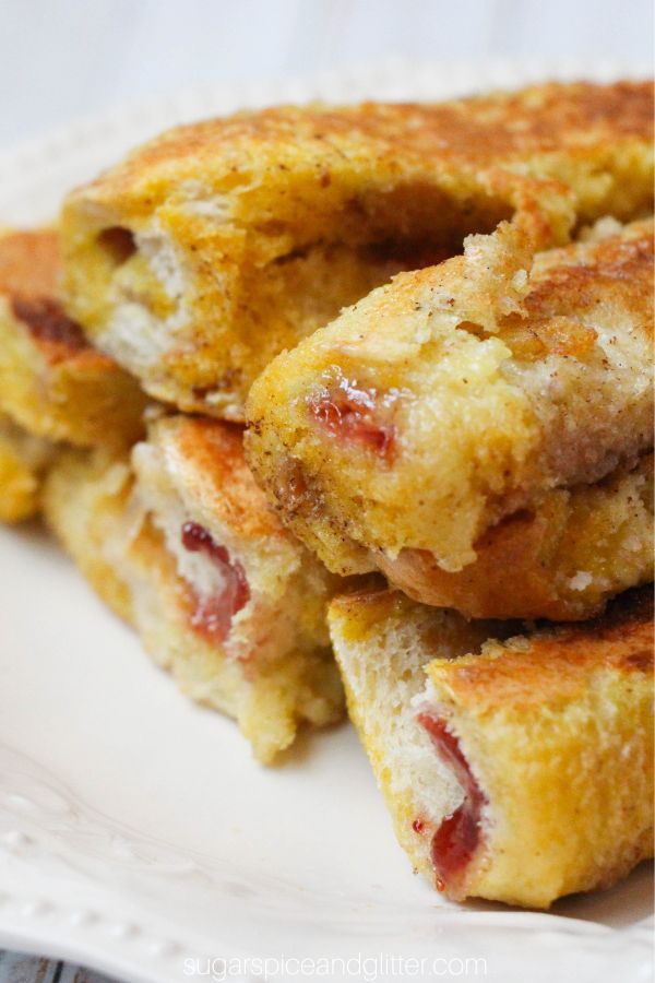 a stack of pb&j french toast roll ups on a white plate