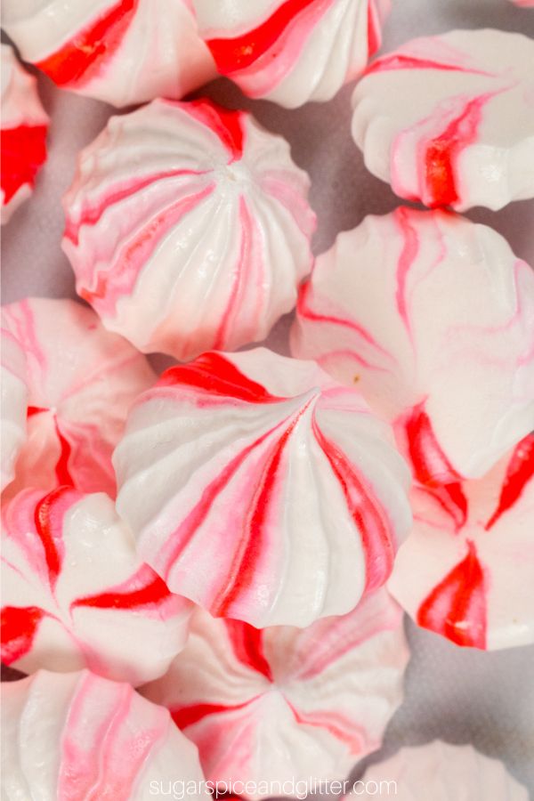 overhead image of a pile of red and white peppermint merinuges