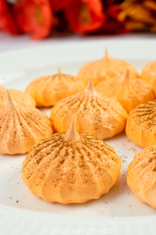 close-up image of pumpkin meringues dusted with pumpkin pie spice on a white plate