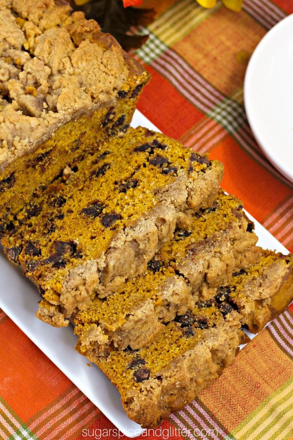 pumpkin coffee cake on a white platter set on an orange plaid tablecloth