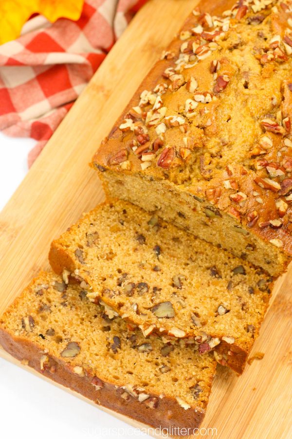 close-up overhead image of a loaf of sweet potato bread topped with toasted pecans