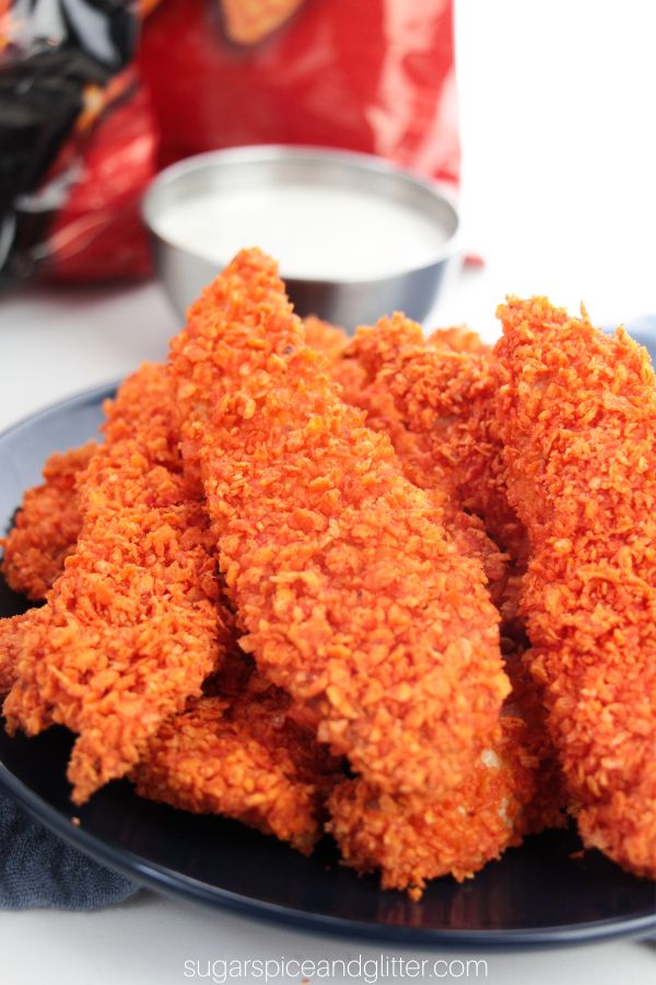 dorito chicken tenders on a blue plate with a bag of Doritos in the background