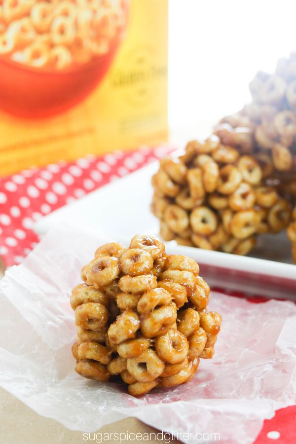 honey nut cheerio balls on a white platter on top of a red polka dot napkin in front of a Cheerios box